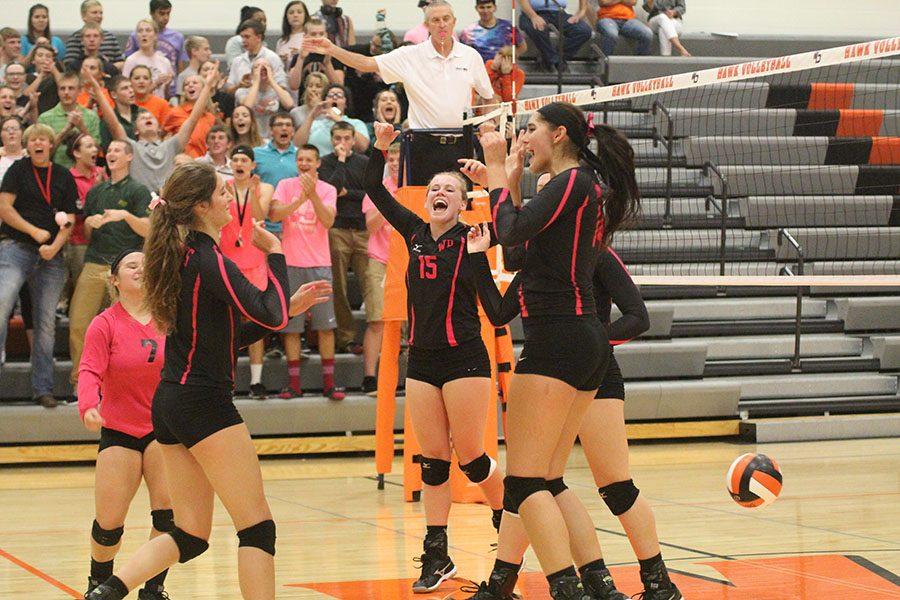 After Scoring a point, Macey Kleitsch (9), Haley Lyness(12), and Ashley Goebel(12) celebrate with their teammates.  