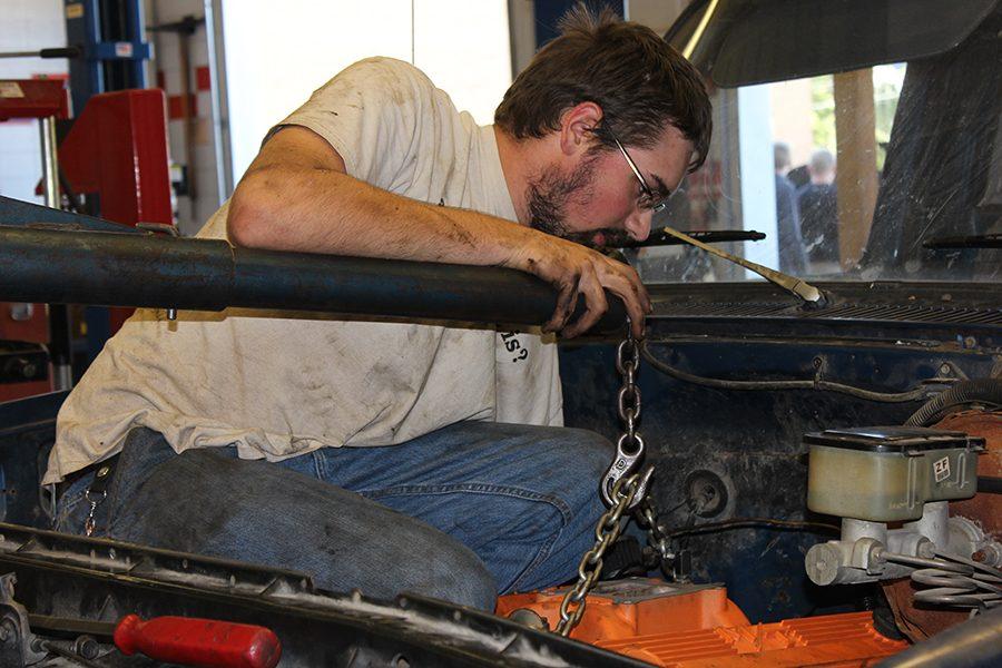 Working in the autos shop, Kin Staton (12) lowers the rebuilt engine into his truck on Sep. 29. 