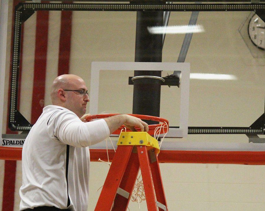 In celebration of becoming WaMaC champs, Coach Matt Uthoff prepares to cut his own piece of the net.