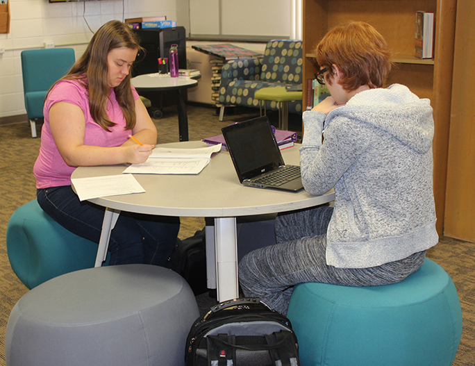 Studying in a newly remodeled library, seniors Abigail Wilson and Alyxandria Schiltz work on homework for the end of the term.