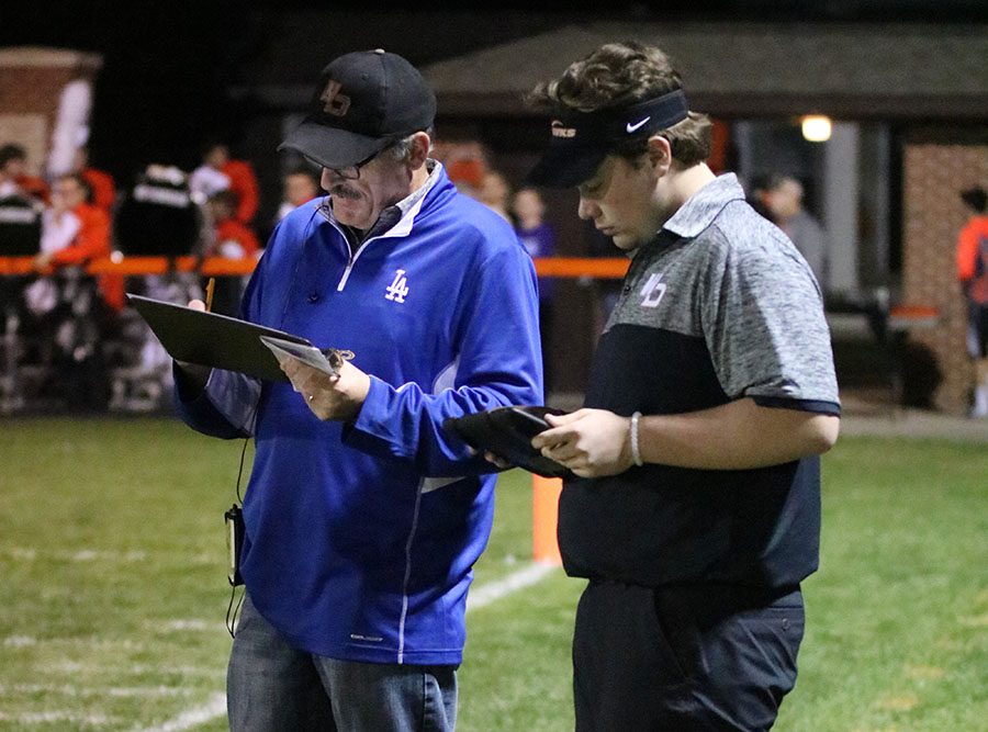 Bill Logan and Dylan Linderwell (12) record stats at the home football game on Oct. 20. 