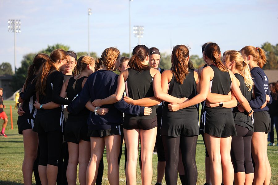 Varsity+and+JV+cross+country+girls+circle+up+for+a+premeet+gathering+at+the+Waverly+meet.