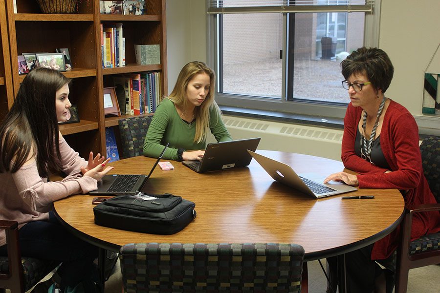 In a meeting with Dr. Kristine Rickey, Megan McDonald (11) and Maddy Gray (11) discuss plans for the school website.