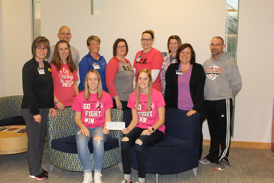 Lauren Collier (12) and Claire Demmer (11) along with Athletic Director Matt Weis and Coach Brett Mather, present the check to the hospital staff.