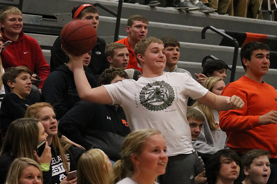 Trying to make the basketball in the hoop, freshman Gavin Tucker launches the ball from the student section.