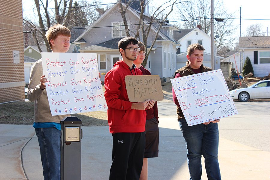 Students respectfully protest against the walkout. Dakota Limkemann (11), Connor Maurer (11), Grant Schmidt (11) and Alex Zumbach (12) hold up signs about protecting gun rights.