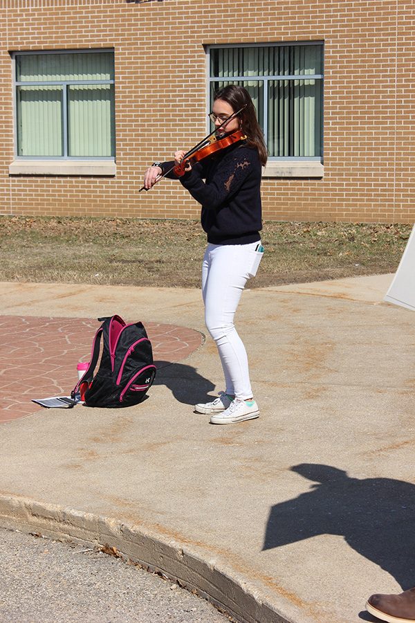 Participating in the walkout, junior Laia López Rigol plays her violin in remembrance of school shooting victims.  