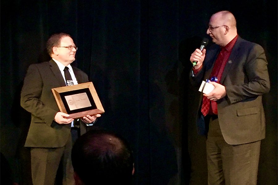 IHSMA Executive Director Alan Greiner presents choral director Duane Philgreen with the Distinguished Service Award.