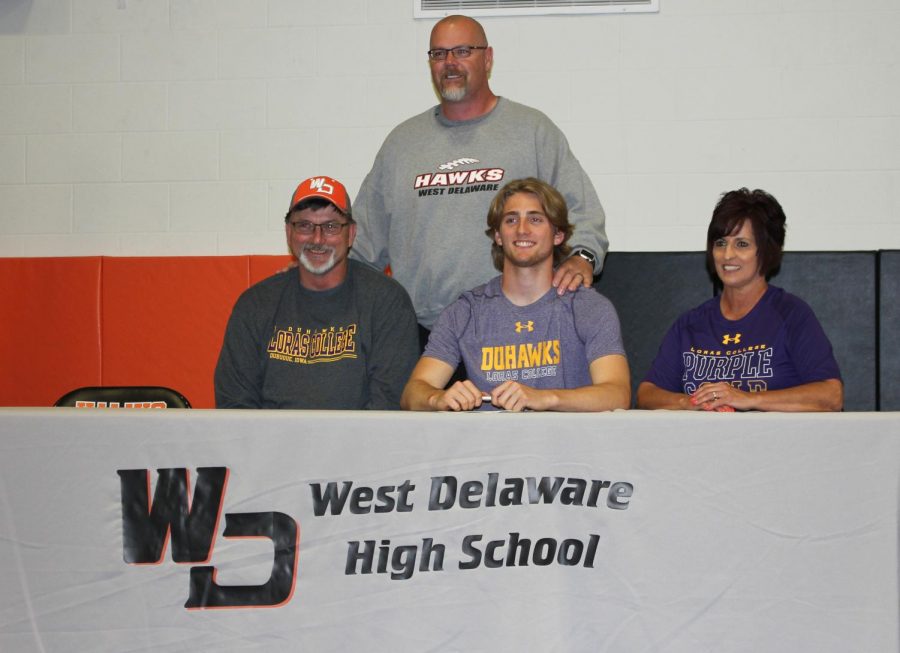After signing with Loras Cook poses with his parents and coach Doug Winkowitsch.