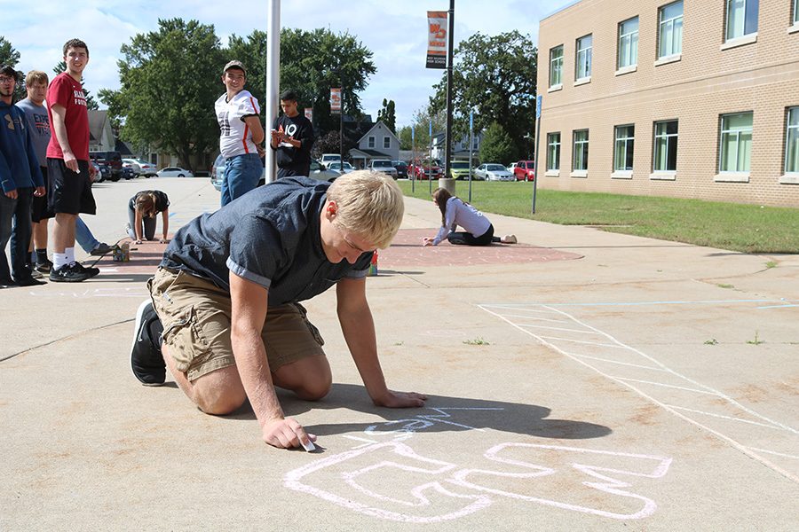 Senior Bryce Tucker and his homeroom were tasked with chalking the sidewalk in front of the school. Every year, students spend the Friday prior to Homecoming decorating the school. 