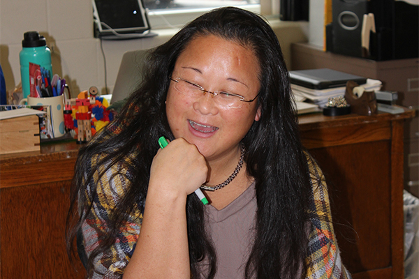 New teacher Jillian Frater sits at her desk while helping students.