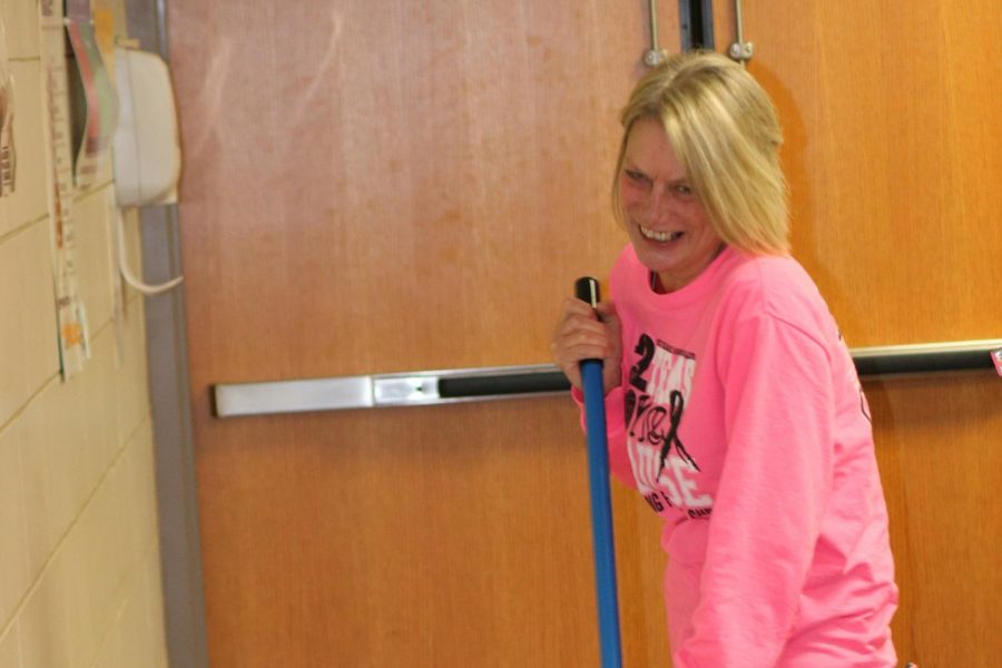 Tutton laughs as she mops the lunch line area before winter break.