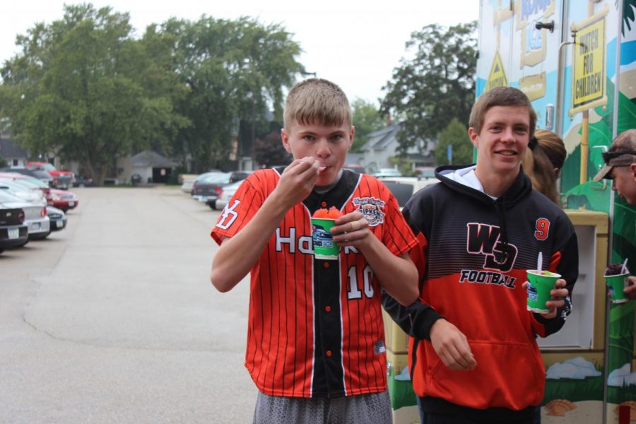 Decked out with spirit, freshman Hayden Lyness and senior Chris LaRosa enjoy their snow cones. The snow cones were free to students who stopped by during lunch.