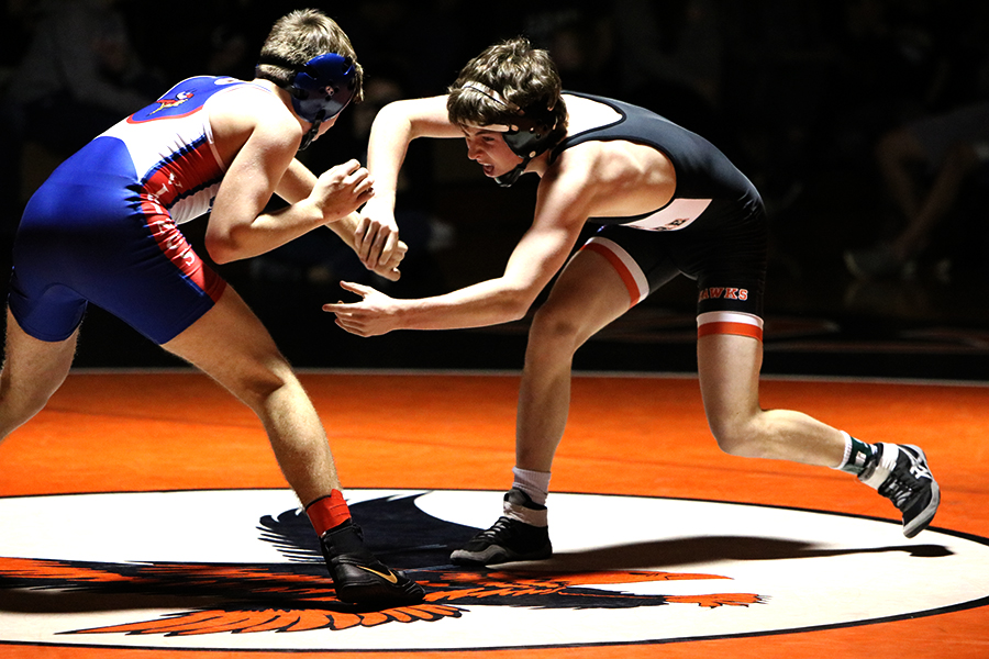 Evan Woods (12) reaches to grab 126-pounder Lane Rolfs hand. Woods beat Rolfs in a major decision of 15-4.