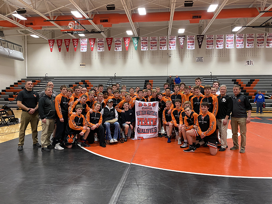 The team smiles with their 2020 state banner after winning both duals.