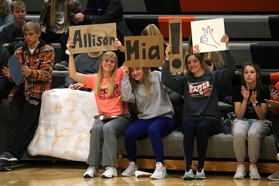 Leah Wegmann (12), Macey Kleistch (12) along with junior Heather Heims support the girls in their game against Solon.