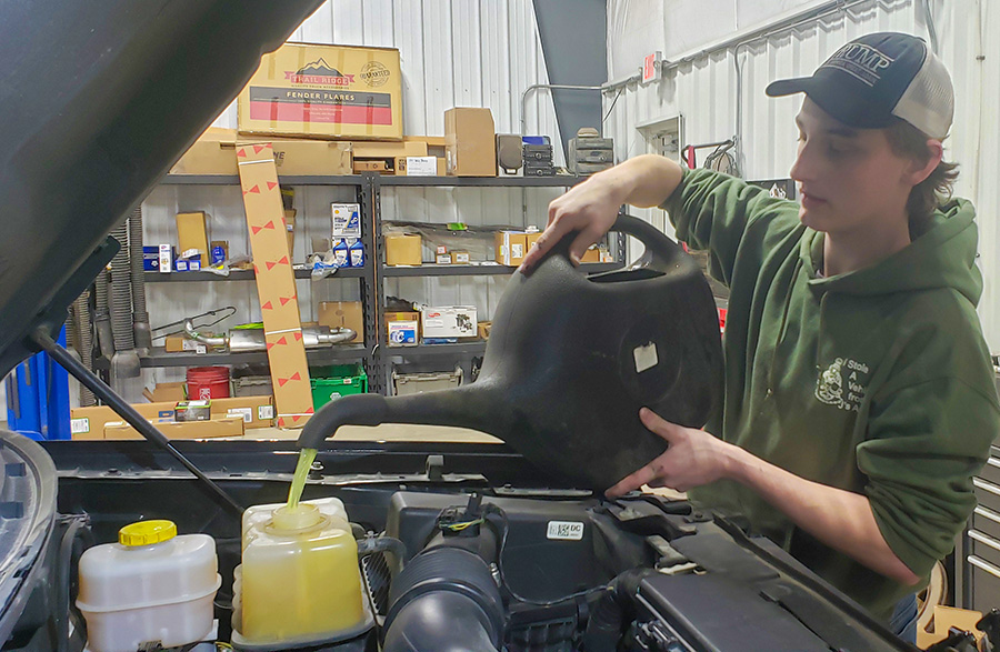 While working at J's Auto, senior Codee Chambers pours antifreeze into a car.