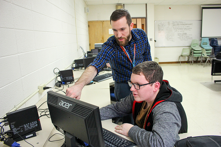 Coach Christian Carper instructs Laiken Blommers (11) at an Esports practice.