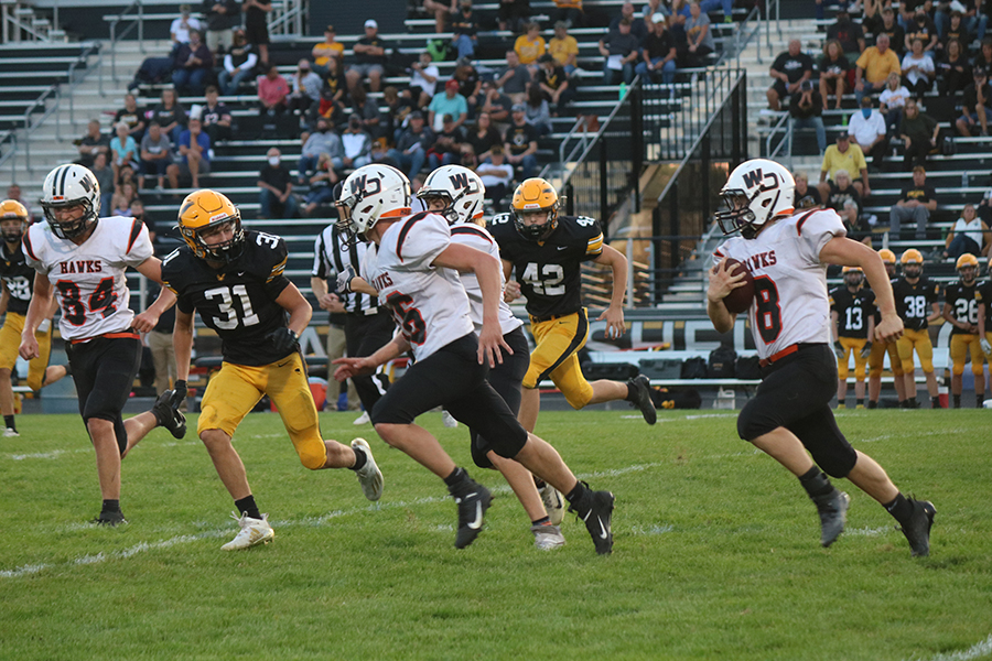 On the Waverly football field, Logan Peyton (10) leads Haze Seibert (9) through the defenders. These two players made up for most of the Hawks rushing yards.
