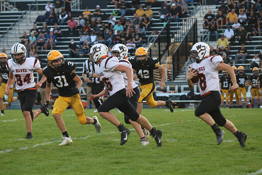 On the Waverly football field, Logan Peyton (10) leads Haze Seibert (9) through the defenders. These two players made up for most of the Hawks' rushing yards.