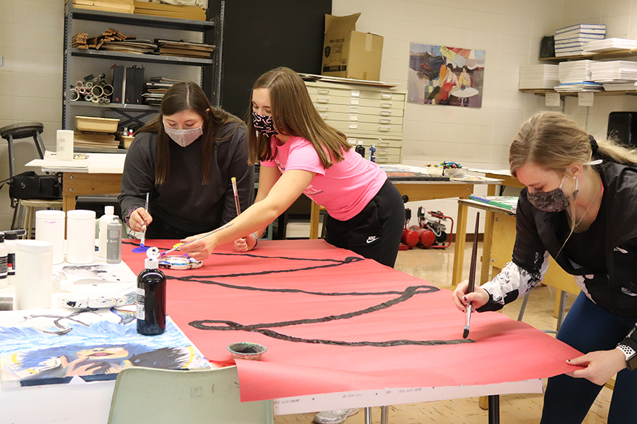 Decorating their door for the holidays, Hallie Wenger (12), Anna Werner (12) and Karsyn Welcher (12) paint Christmas lights onto a sheet of paper for their door.