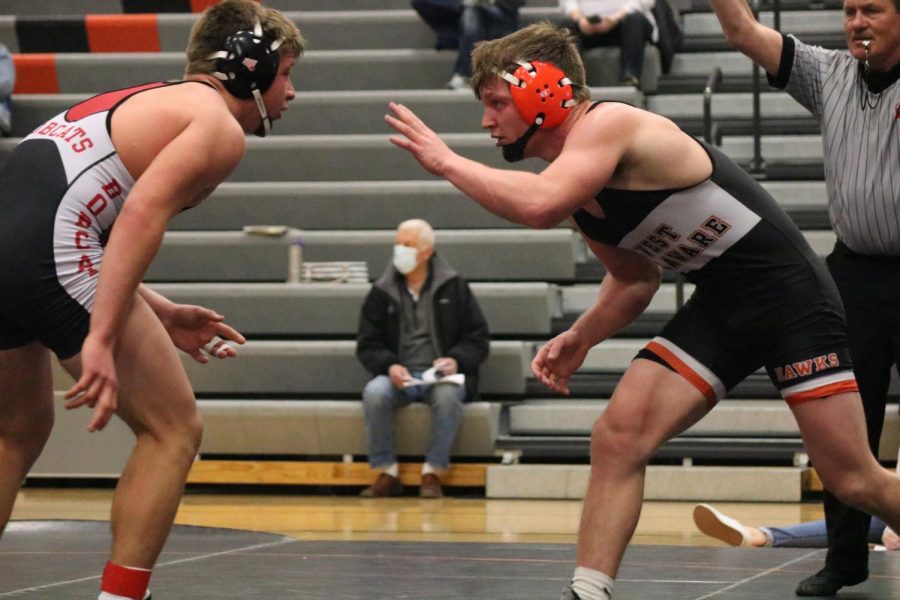 Attempting to lock up with his opponent, senior Cael Meyer reaches at Western Dubuque wrestler.