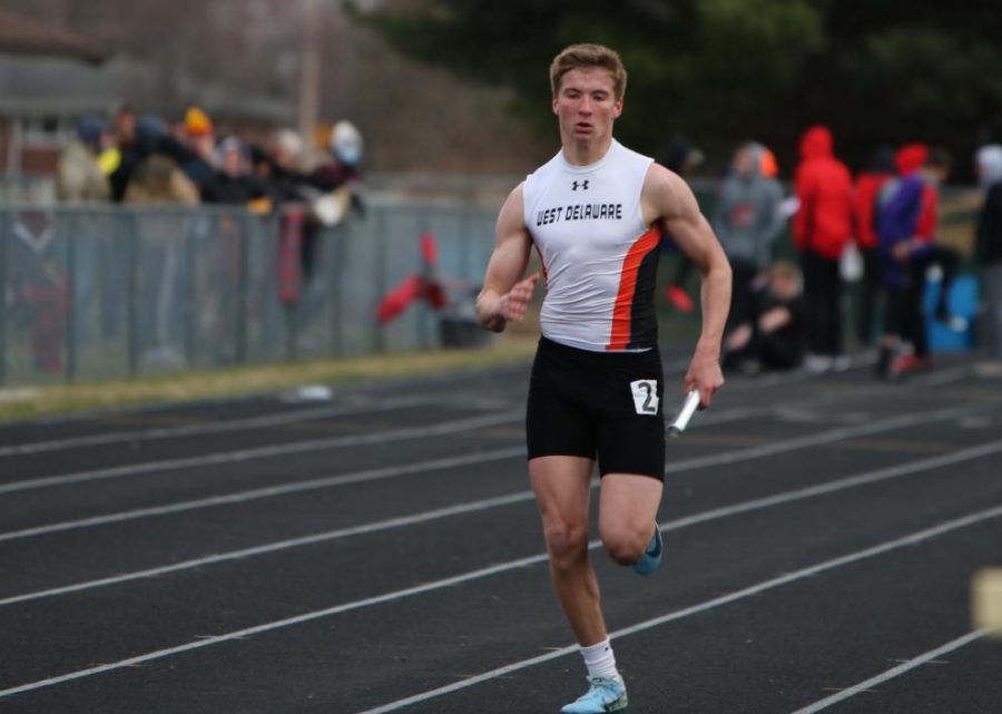 Racing in the 3200 
Medley Relay, Jack Smith (9) competes in the opening home meet. Smith placed third in the 3200 Medley relay and helped the team earn sixth in overall team points.