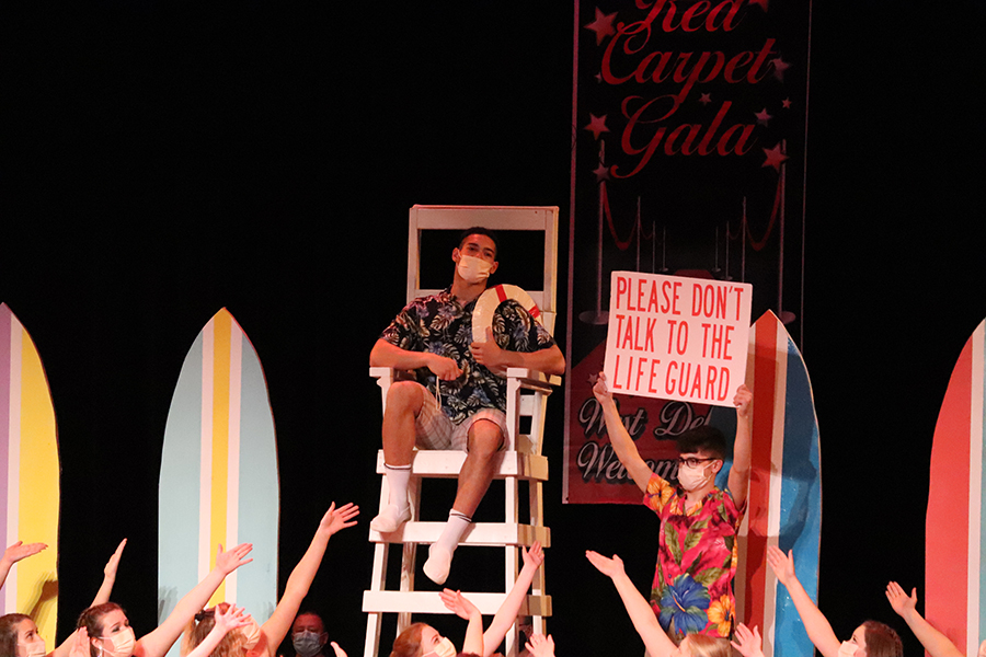 During the song "Please Don't Talk to the Lifeguard," Andrew Salas (12) shows a sign to prevent the fangirls from talking to lifeguard Christian Nunley (12).