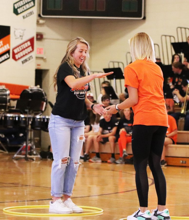 Aggressively jumping through hula hoops on Friday in the Homecoming Olympics, Carlee Smith (12) and Ava Bockenstedt (10) meet in the middle to play a game of rock paper scissors. Smith won and moved on to secure the win for the seniors over the sophomores.