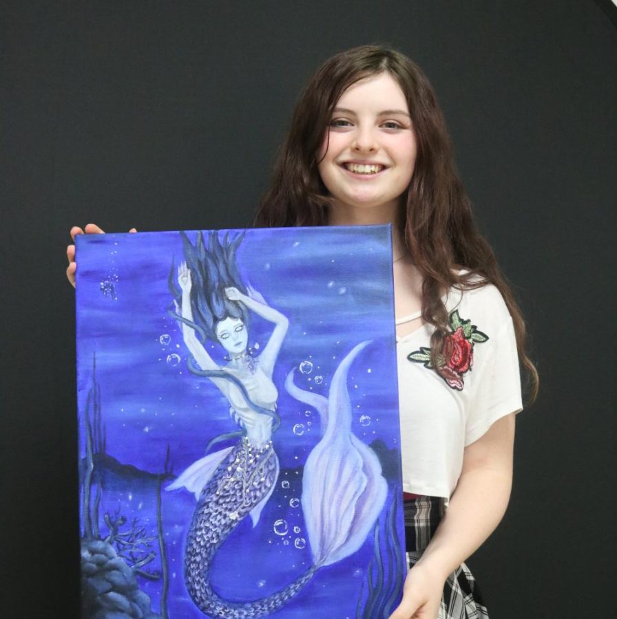 Senior Hallie Knutson shows off one of her many paintings.
