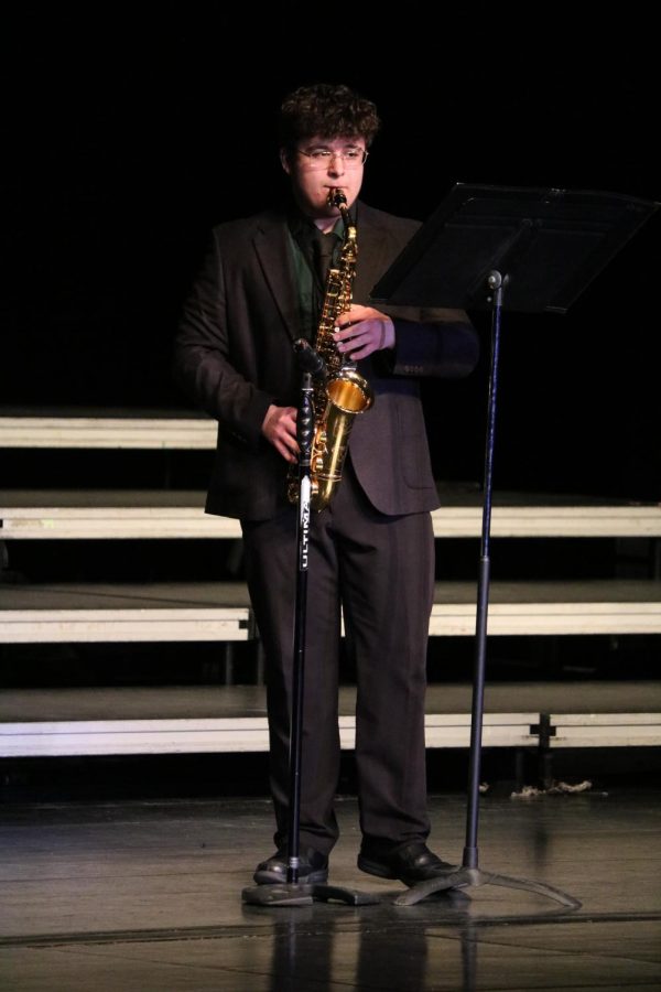 Playing the saxaphone, Lucas Beilby performs Prince Charming during Swing Into Spring.