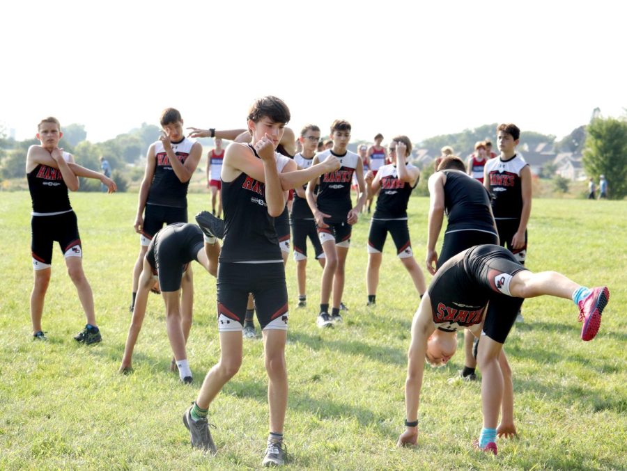 The freshmen and sophomore boys cross country team stretch before a grueling Waverly Shell Rock course. 