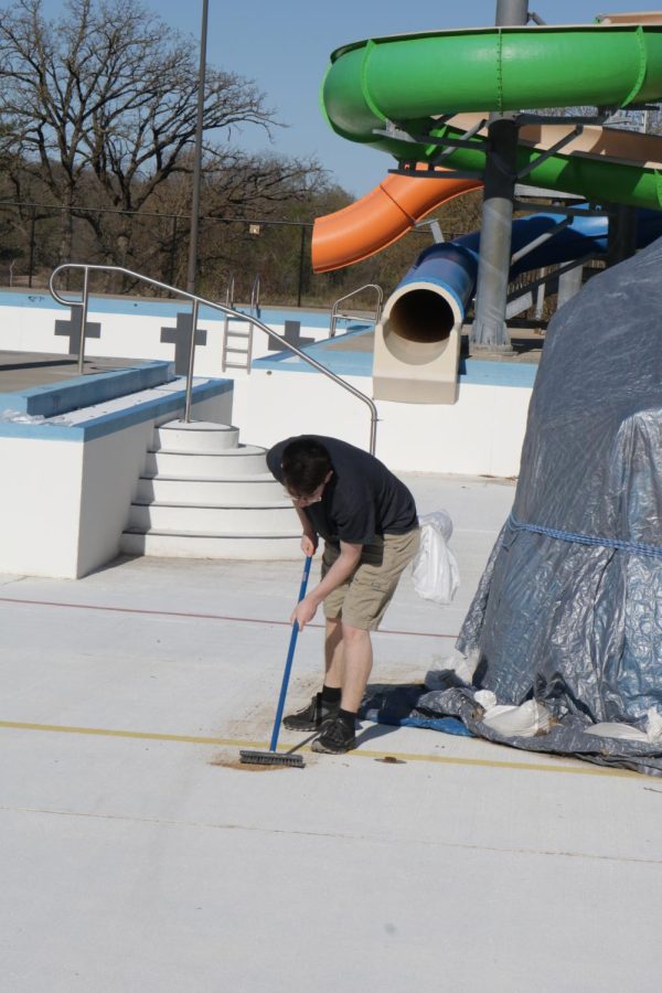 At the Kramer Aquatic Center, Kaeleb Sickels (12) sweeps the pool before it is filled with water.