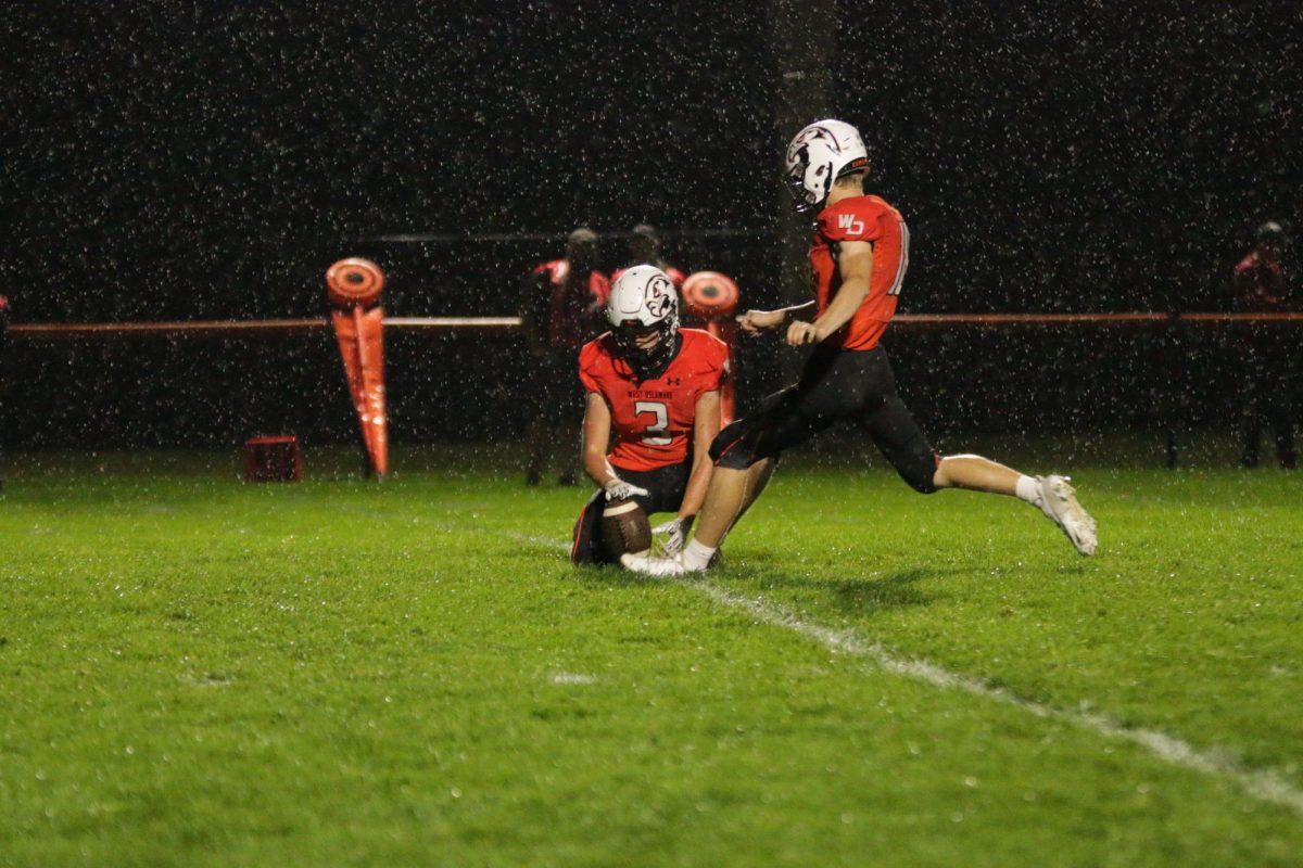 Out of the hold of senior Conrad Smith (3), junior kicker Christian Timmerman (18) attempts an extra point. Timmerman barely missed both extra points against Maquoketa.