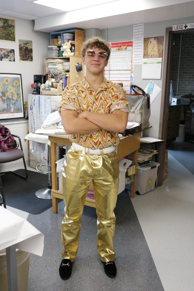 For homecoming dress-up days, senior Max Anderson blings out in a golden outfit for Denim and Disco day.