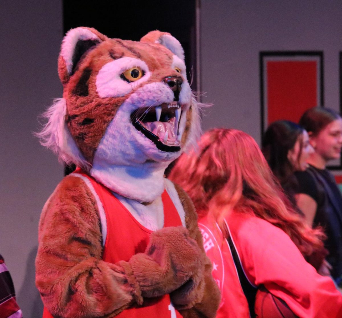 Freshman Eli Shipley parades around the stage in a Wildcat mascot costume during a performance. 