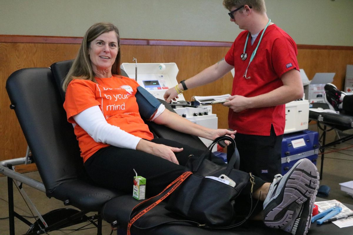Continuing her lifelong habit, teacher Mary Wegmann smiles for a photo while donating blood. 
