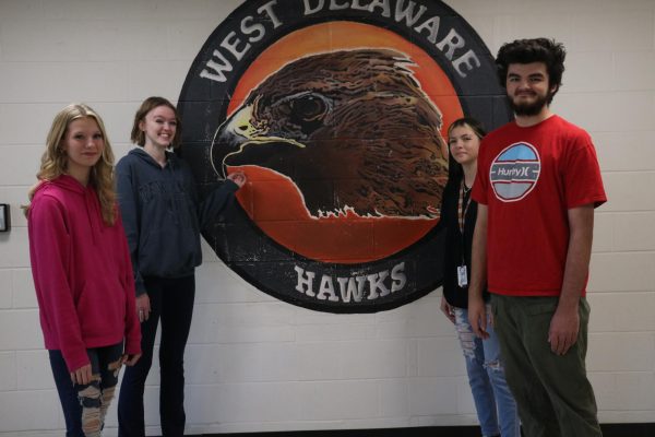 Noelle Bardgett (second to the left) is one of the people who showed new students Harley Goodman (11), Sydnee Feliciano (10), and Michael Eadens (9) around West Delaware. 