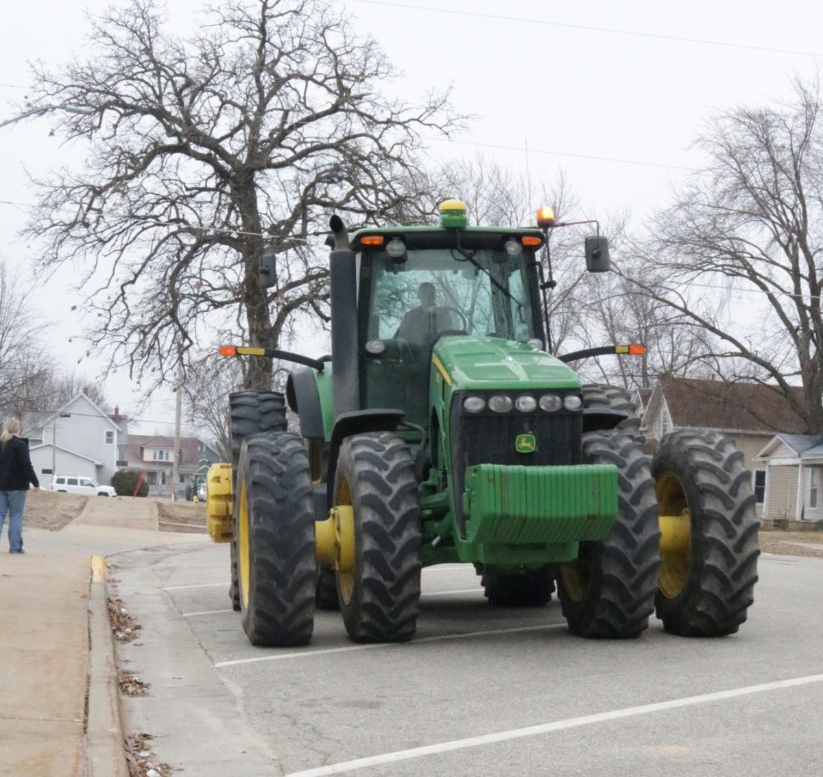 An FFA member drives his John Deere tractor to school. Students watched his tractor as he pulled in. 