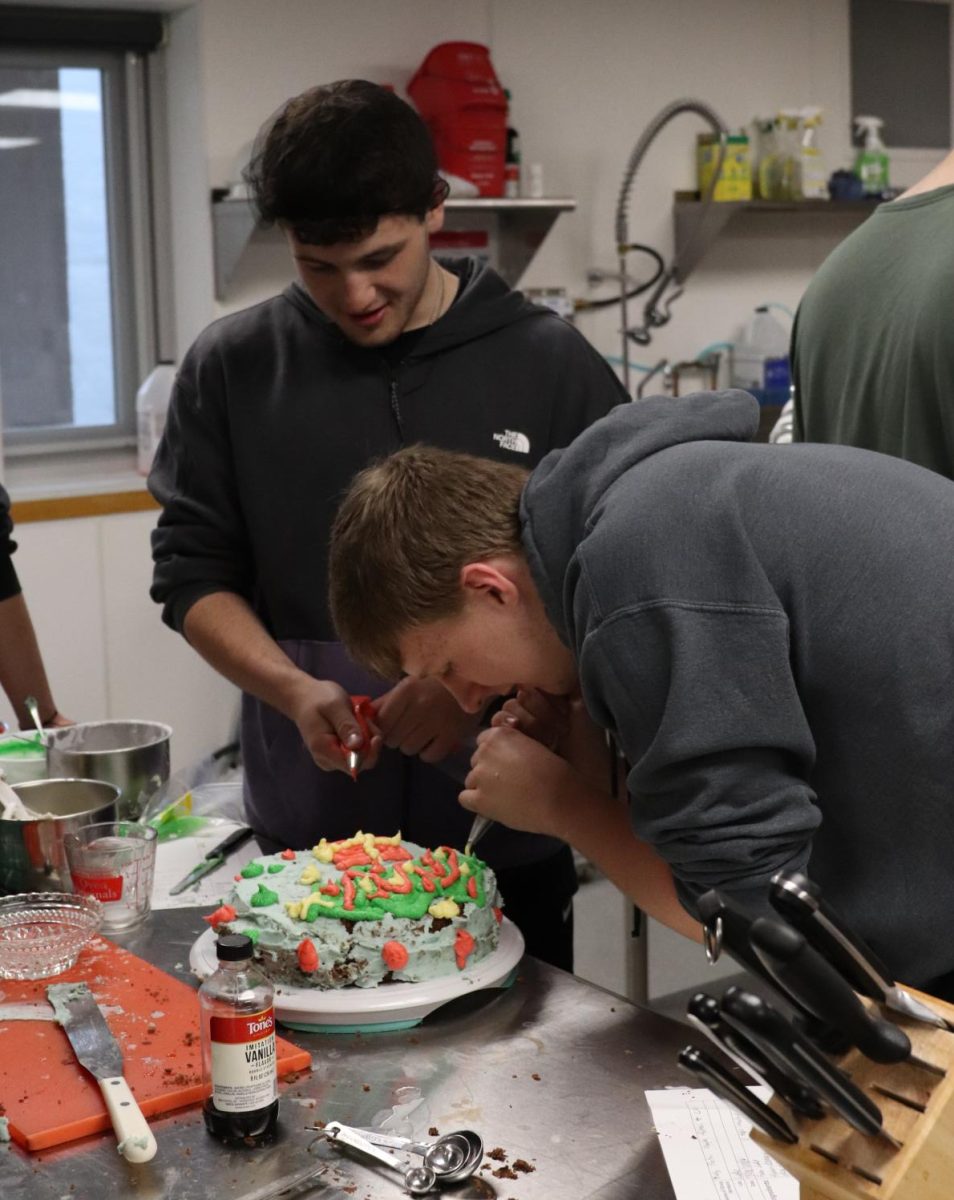 In Foods II, seniors Bosten McAulay and Brody Kafer have fun decorating their cake.