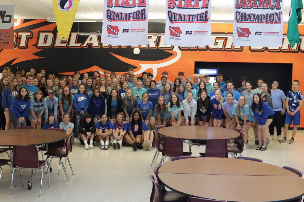 Wearing blue, over 100 students pose for a photo to show support.