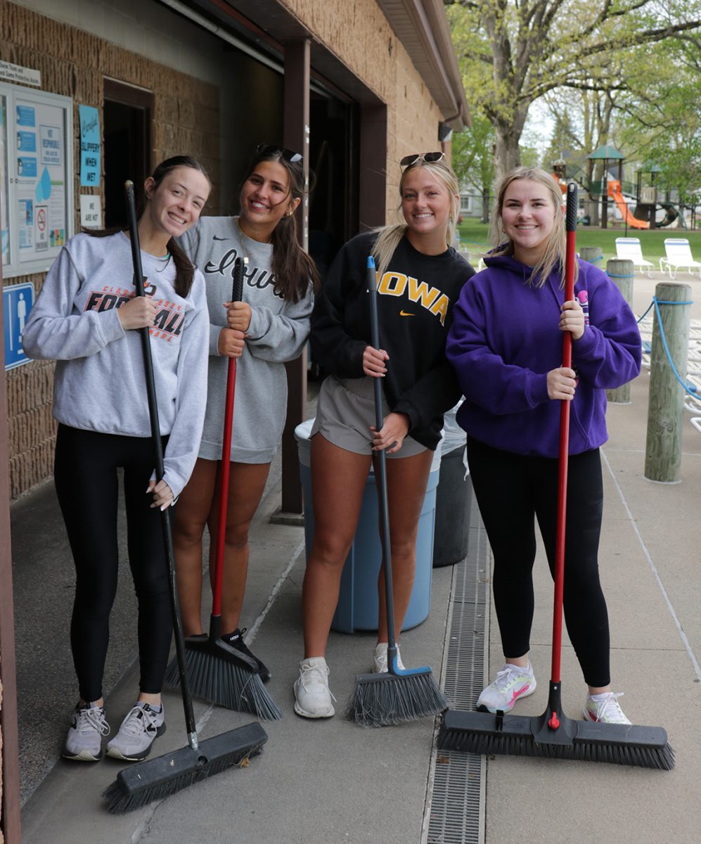 Seniors Stephanie La Rosa, Maddie Hildebrand, Gracie Lynch, and Ava Timmerman take a break from sweeping to smile for a picture. They spent their senior service day cleaning up the Manchester Aquatic Center.