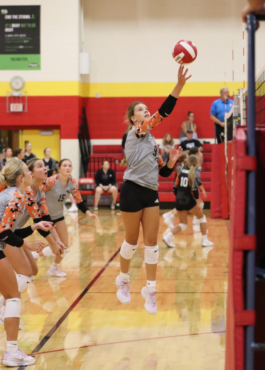 While playing against the Marion Wolves, junior Emma Schmidt tips the ball to help the JV Hawks win, 2-0.