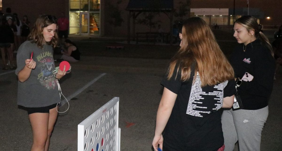 On Monday night during Homecoming Week, Avery Carroll, Parker Robinson, and Katie Kass play Connect Four. Student council hosted a game night filled with games, pizza, and Kona Ice. 