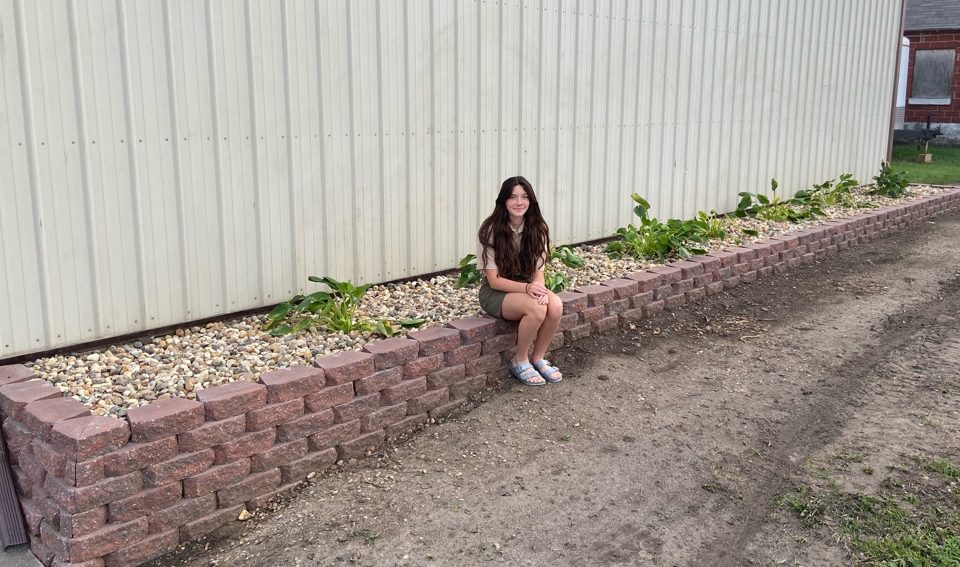 Erin Mensen poses with her finished landscaping project at the Masonville Fire Department. This project took Mensen over 10 hours to complete.
(Photo Contributed)