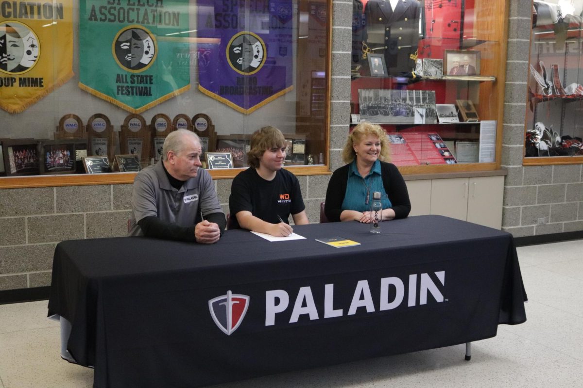 Junior Lyle Cassel signs his letter of intent  with Paladin Attachments. With Cassel is Paladin second shift group leader, Larry McDonough, left, and Kristie Austin, Paladin senior human resources generalist, right. 