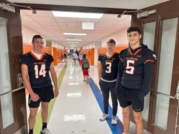 Volunteering for High Five Friday, Caleb Stocks (12), Ryan Hilby (12), and Saul Barron (12) spread positivity. 