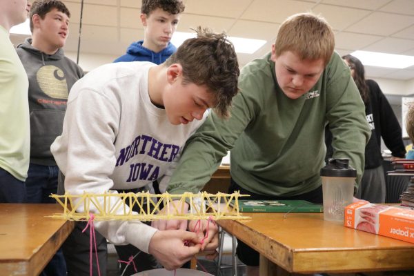 Jakob Jones-Hutchinson (9) holds the bucket in the center as Lane Gudenkauf (9) ties it to the noodle bridge. "It showed the importance of building strong structures," Gudenkauf said. 