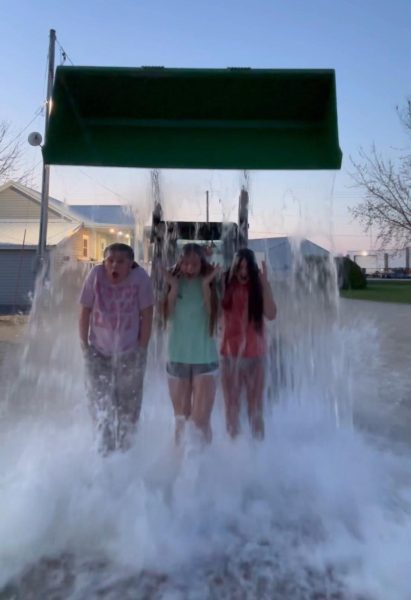 Getting over 10 gallons of water dumped on their heads, Tess Thomsen (10), Ruby Dolan (9), and Vivian Clar (9) react to the cold water. (Picture taken from video of the girls doing the challenge)