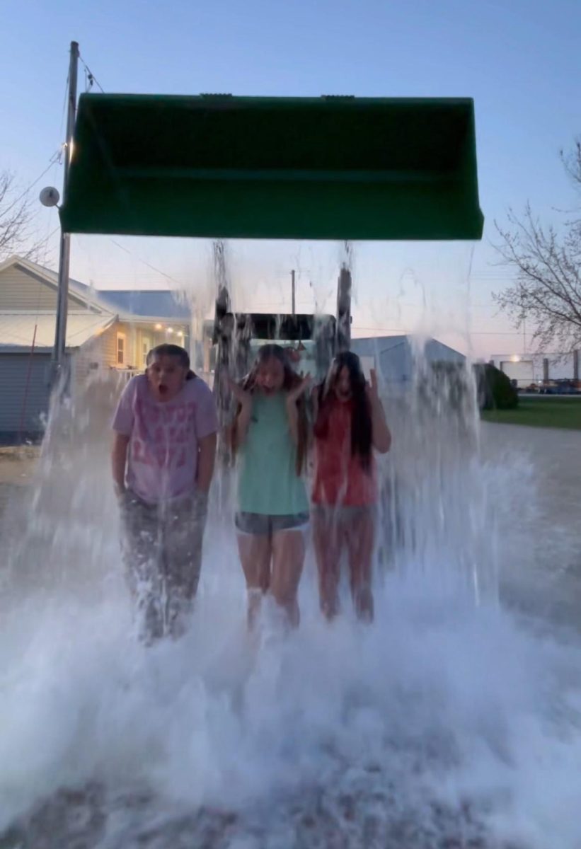 Getting over 10 gallons of water dumped on their heads, Tess Thomsen (10), Ruby Dolan (9), and Vivian Clar (9) react to the cold water. (Picture taken from video of the girls doing the challenge)